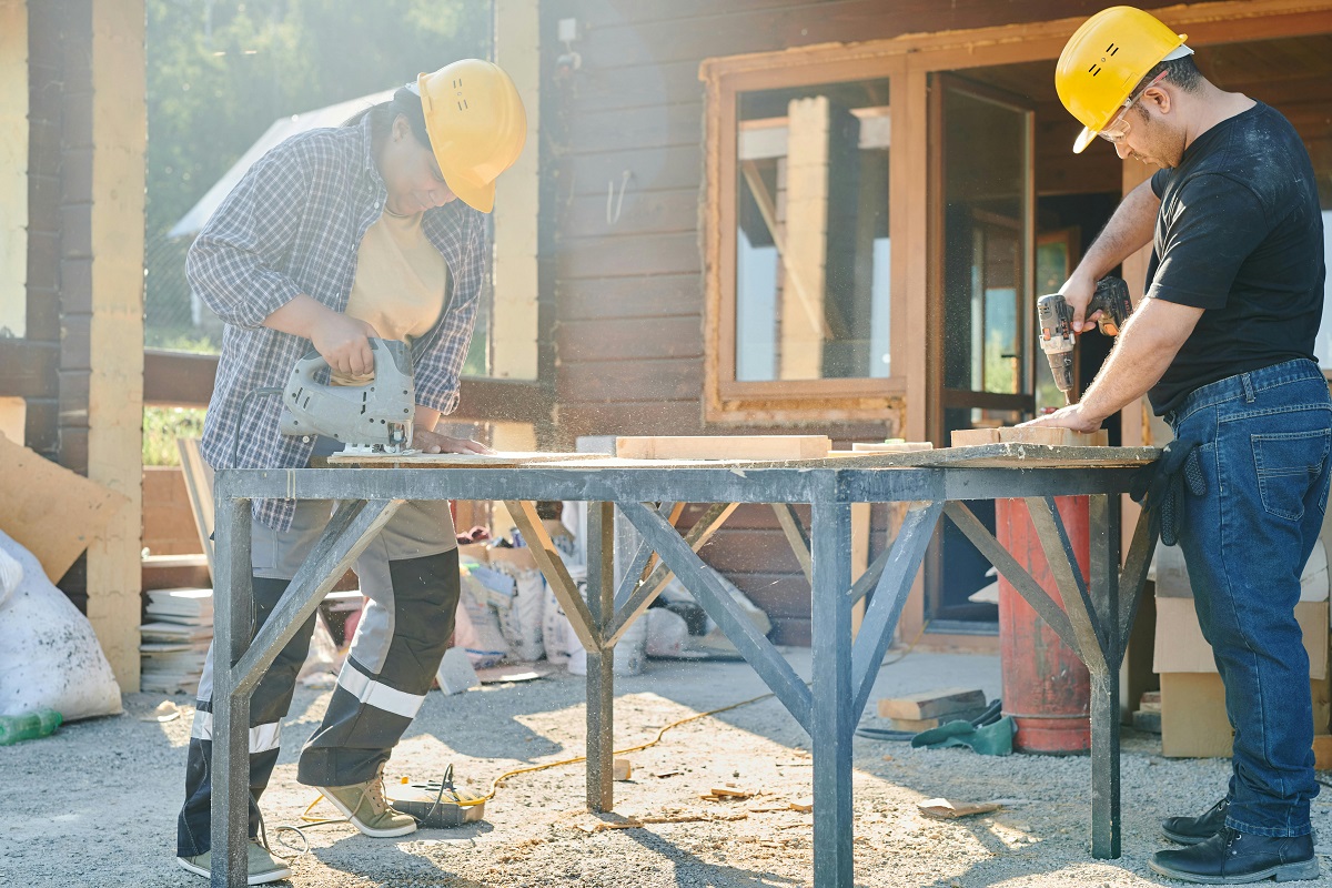 man and woman working together on a DIY project, drilling into a wooden board